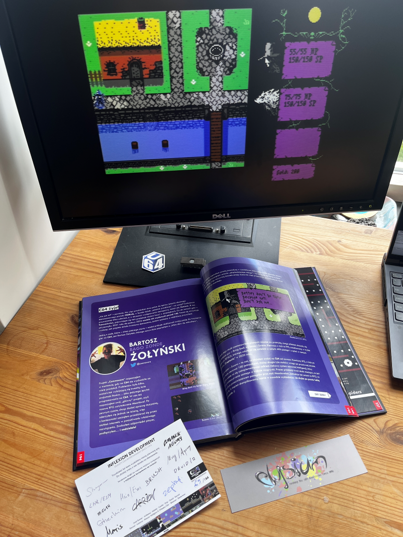 Book opened on the page where Commocore's games are featured, with big screenshot from Meonlawel cRPG and comparison with the current version of the game on the monitor screen